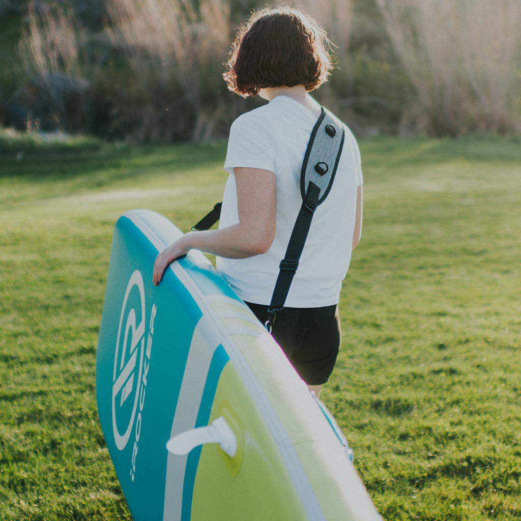 Person carrying paddle board with Carry strap