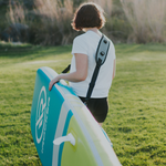 Person carrying paddle board with Carry strap | Lifestyle
